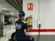 Técnico de A2J instalando un extintor especializado de Vermiculita (AVD) para fuegos de litio cerca de un cargador de coche eléctrico en Alcalá.